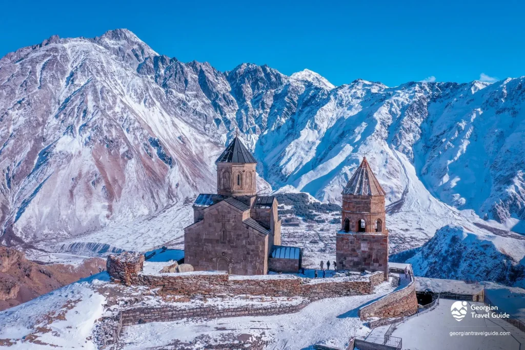Gergeti Trinity Church in Kazbegi with Mount Kazbek view, best destination to visit by rental car from Tbilisi