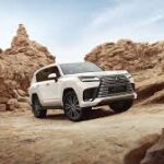 White Lexus LX luxury SUV off-road in Georgian mountains.