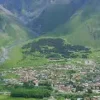 Mountain landscape of Kazbegi with valley and Caucasus peaks, travel destination from Tbilisi by rental car
